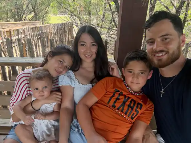 Lane and Sasha White with their three kids on a wooden porch in the Texas Hill Country